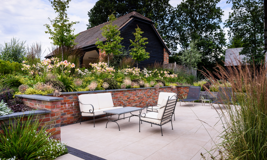 Porcelain paved terrace with brick retaining walls and slate coping