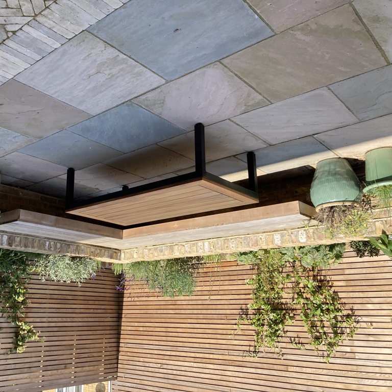 Built-in 'floating' cedar corner bench with brick raised planting border behind