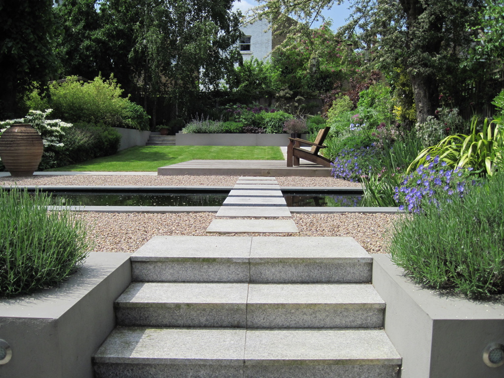 Stepping stones across formal pond to cedar deck