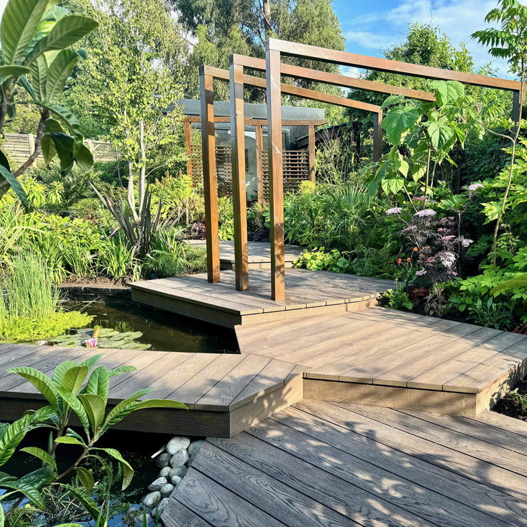 Multi-level decks leading up the garden through exotic planting